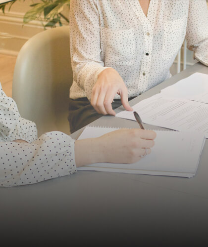 Image zoomée sur les feuilles partagées par deux femmes. Cette image est utilisée pour représenter le parcours de négociation proposée par Jérôme NOGUER