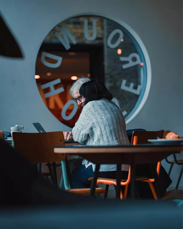 Couple qui travaille autour d'un ordinateur pour illustrer l'écoute dans le couple dans un environnement de travail.